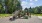  A playground with a green slide and a wooden structure.